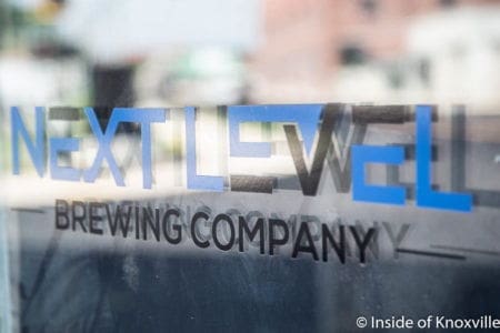 Next Level Brewing Company logo on glass window.