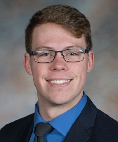 Young man in glasses wearing a suit and tie.