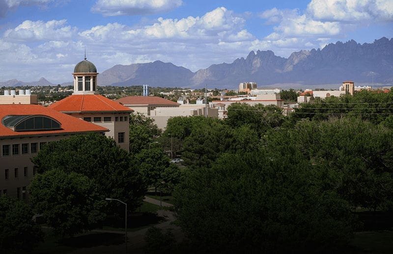 University campus with mountains and blue sky backdrop.