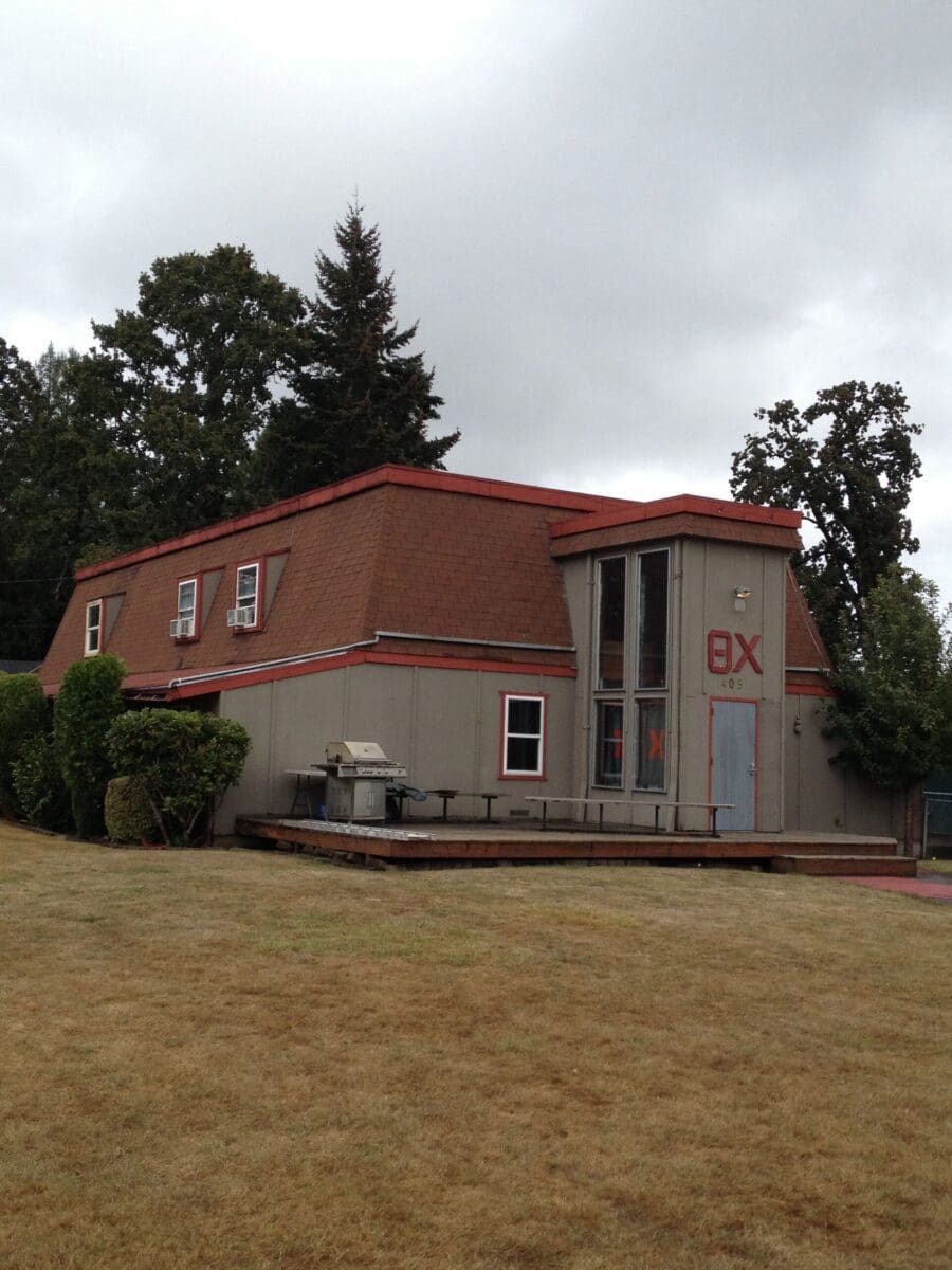 Two-story building with a red roof and patio.