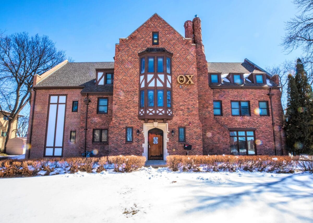 Historic brick building with snowy landscape and clear sky.