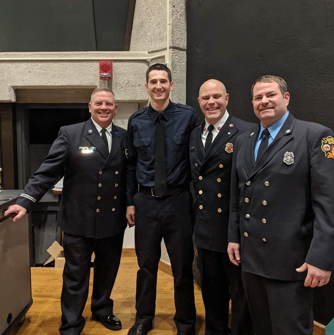 Phil Hall Four firefighters posing together at an event.