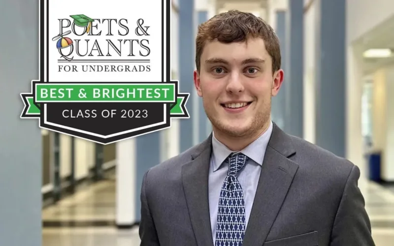 Smiling graduate in professional attire, Class of 2023.