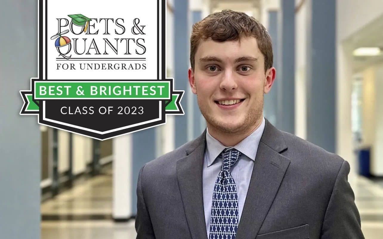 Smiling graduate in professional attire, Class of 2023.