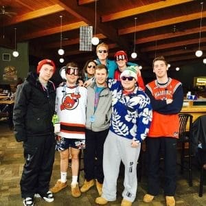 Group of friends in winter attire at a lodge.