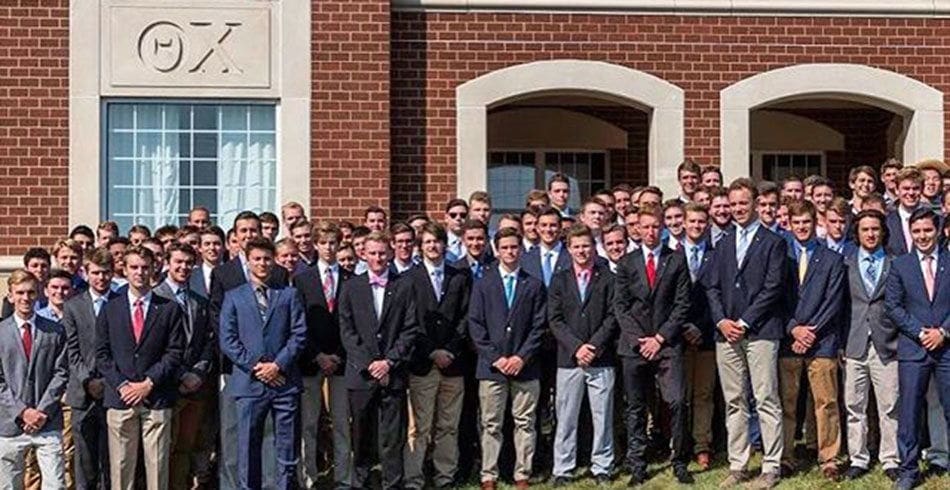Purdue Group of young men in formal attire outside building.