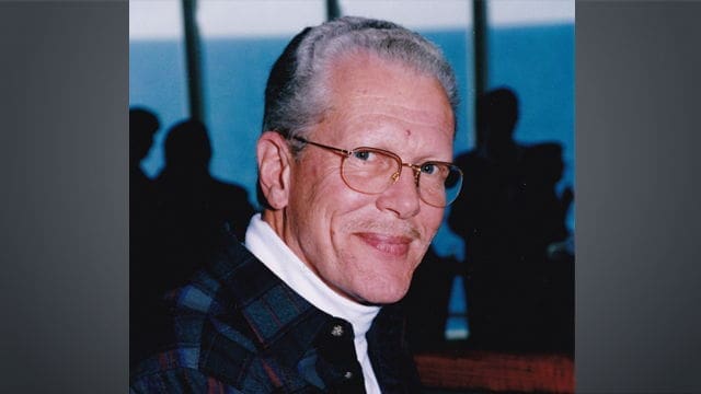 Ralph Miller (2) Smiling older man with glasses and plaid shirt.