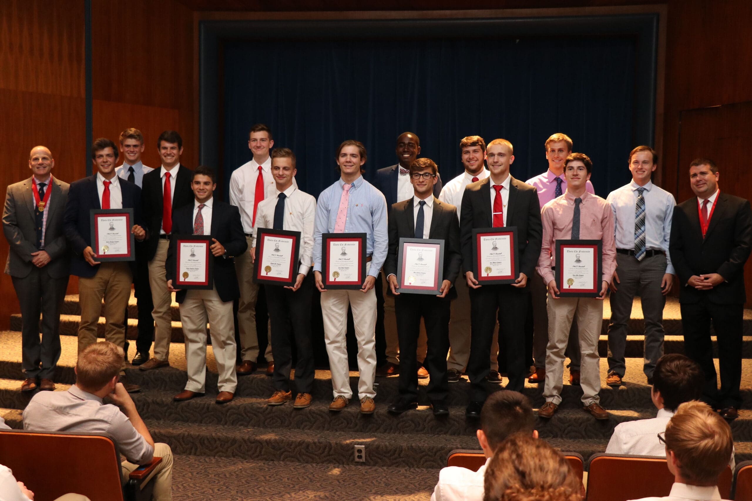 Group of students holding awards at recognition ceremony.
