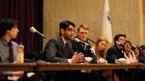 Panel discussion featuring four speakers at a table.