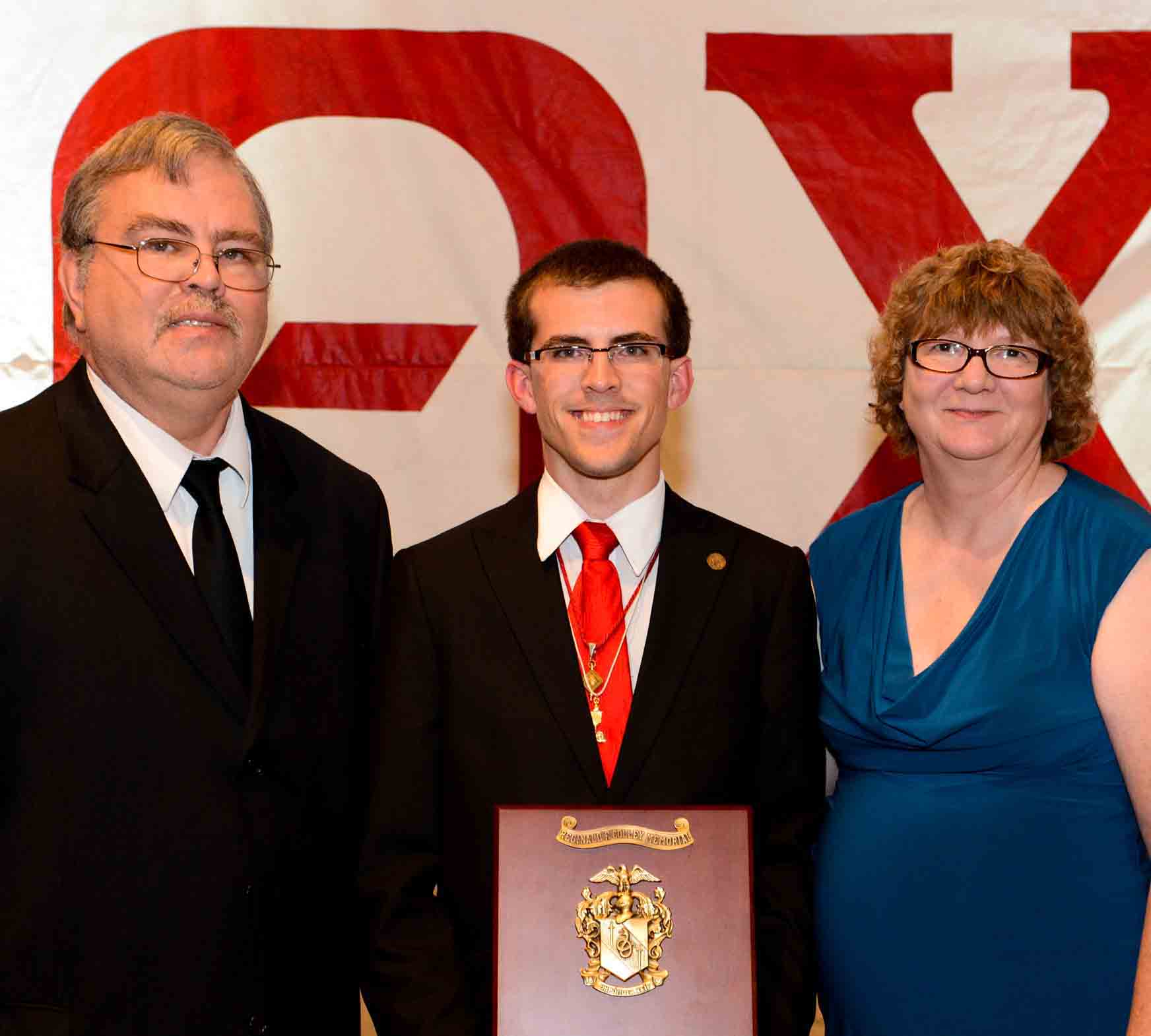 Graduation ceremony with proud parents and son.