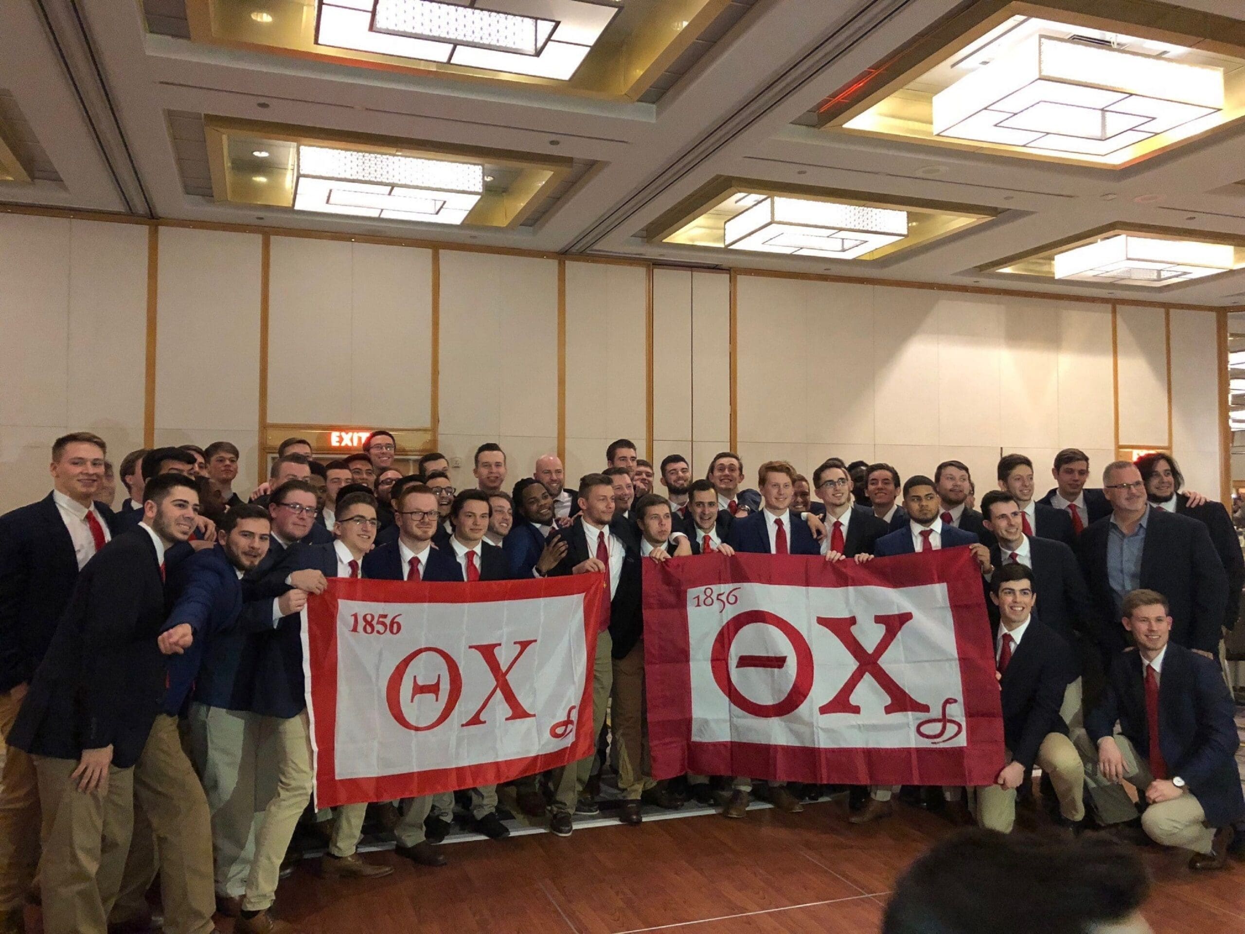 Rider Reinstall Group of fraternity members holding flags at event.