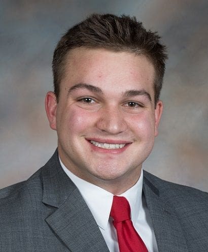 Smiling young man in formal attire portrait.