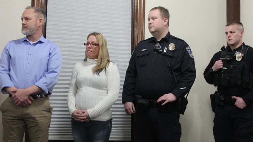 Robert Moody Woman and police officer standing indoors together.