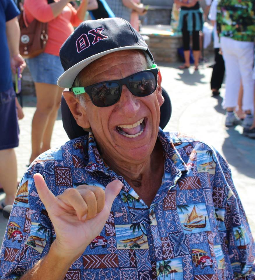 Smiling man in sunglasses making shaka sign.