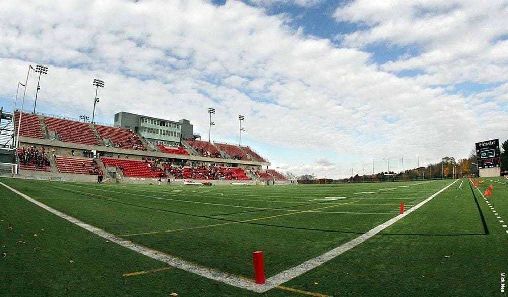 Empty football stadium under a cloudy sky.