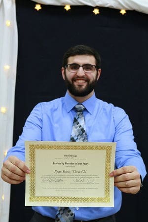 Man holding Fraternity Member of the Year certificate.