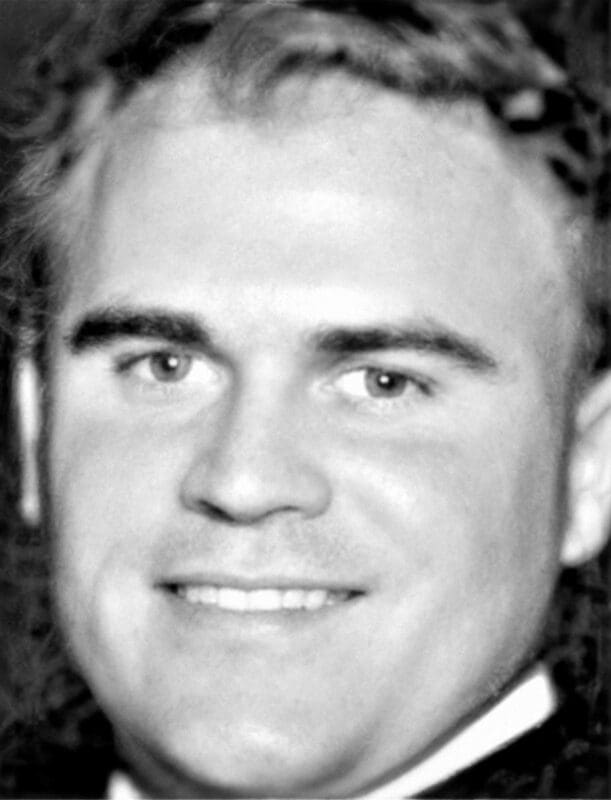 Smiling man in a black and white photo.