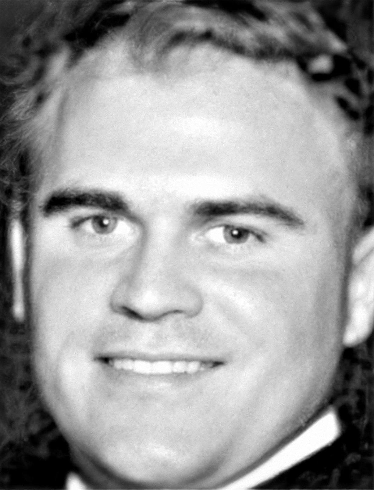 Smiling man in a black and white photo.