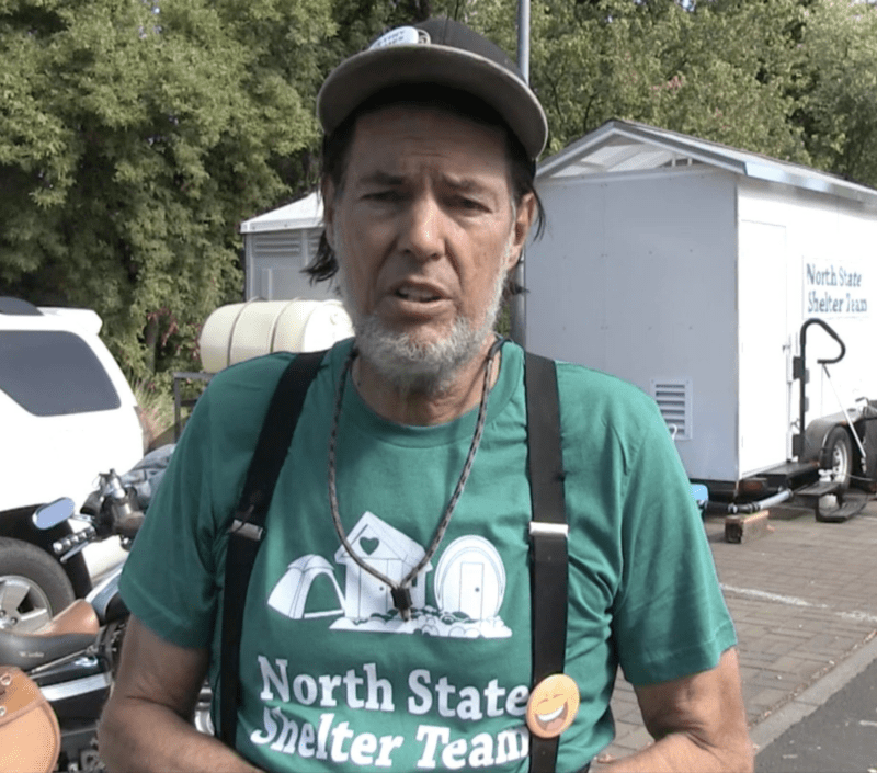 Man in green shirt promoting shelter team.