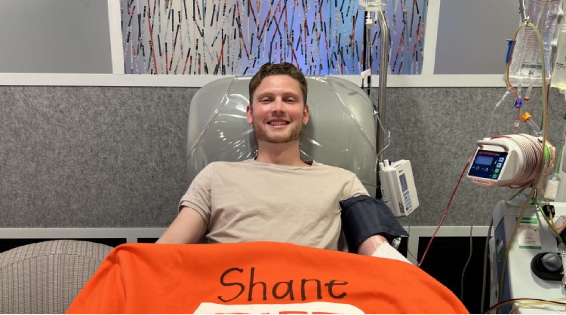 Smiling man donating blood in medical facility.