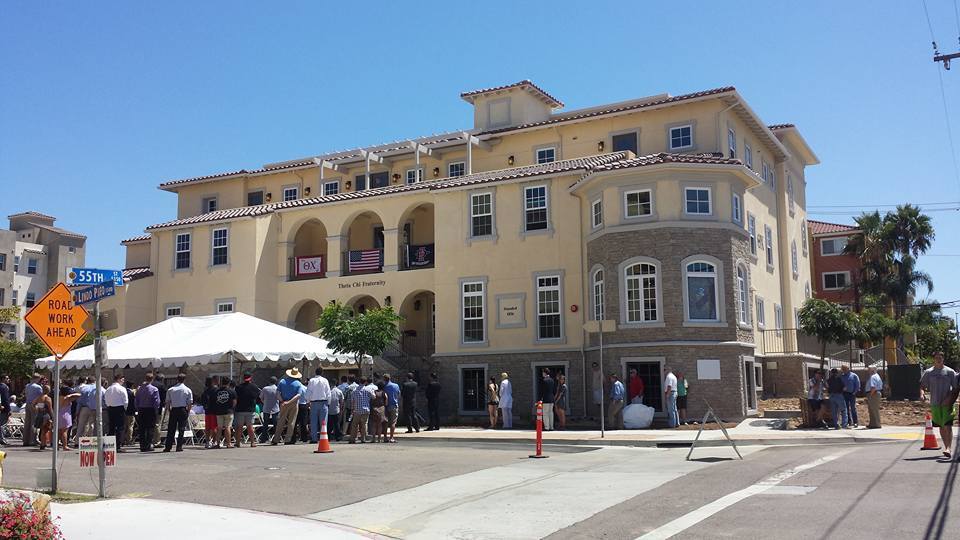 Historic building with people gathering outside.