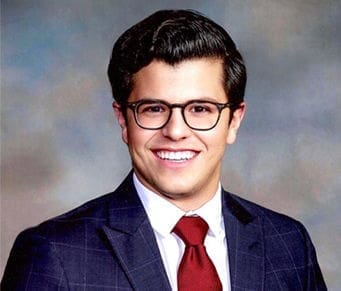 Professional man in suit with glasses and smile.