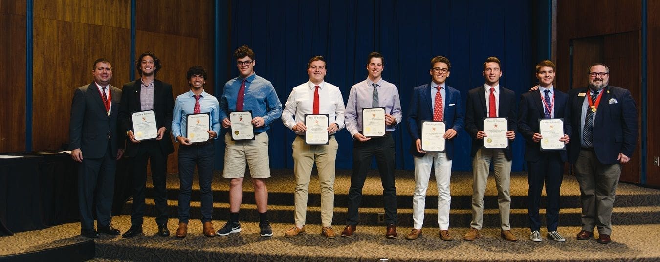 2018/2019 Excellence Awards Students proudly displaying achievement certificates on stage.