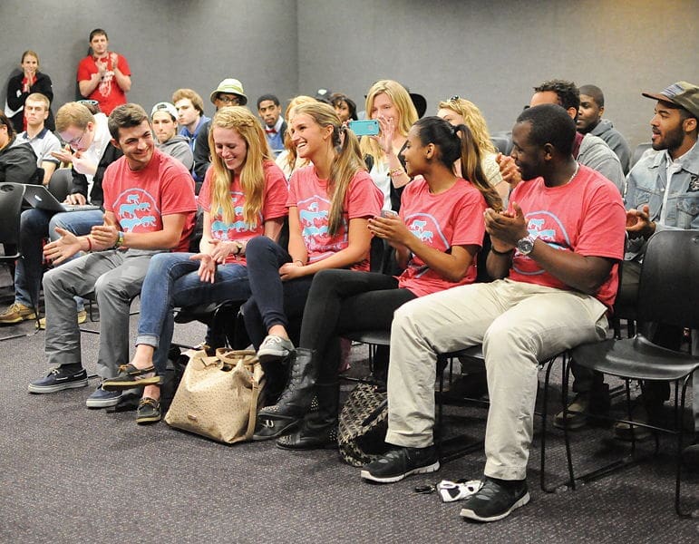 Group of students engaged at an event, smiling.