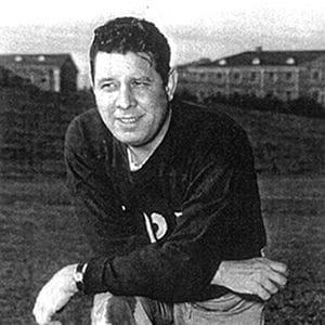 Historic black-and-white photo of a smiling athlete.