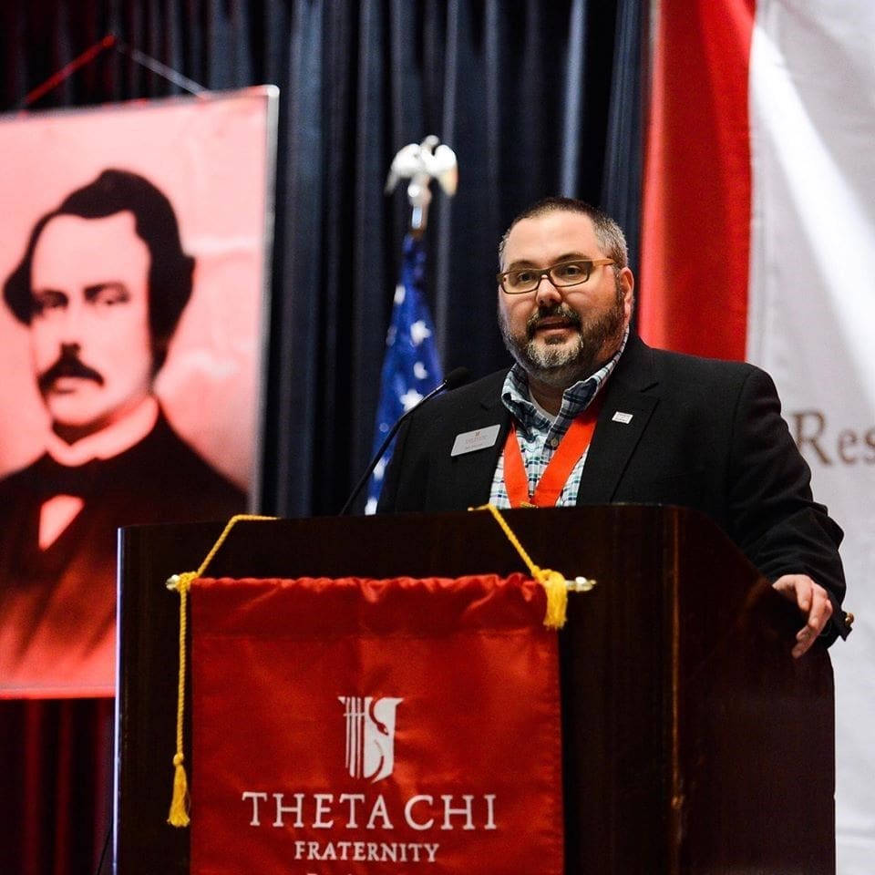 Tait Martin Speaker at Theta Chi Fraternity event with banner.