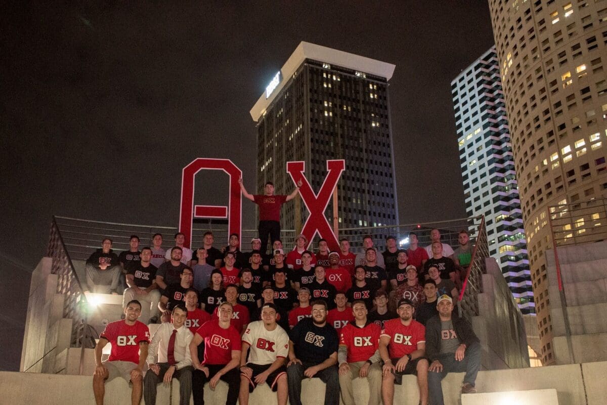 Group photo with large letters A, B, X at night.
