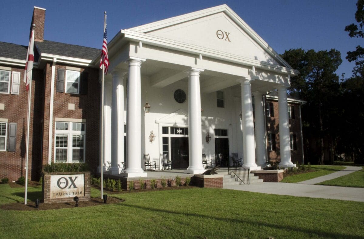 Fraternity house with columns and American flag.