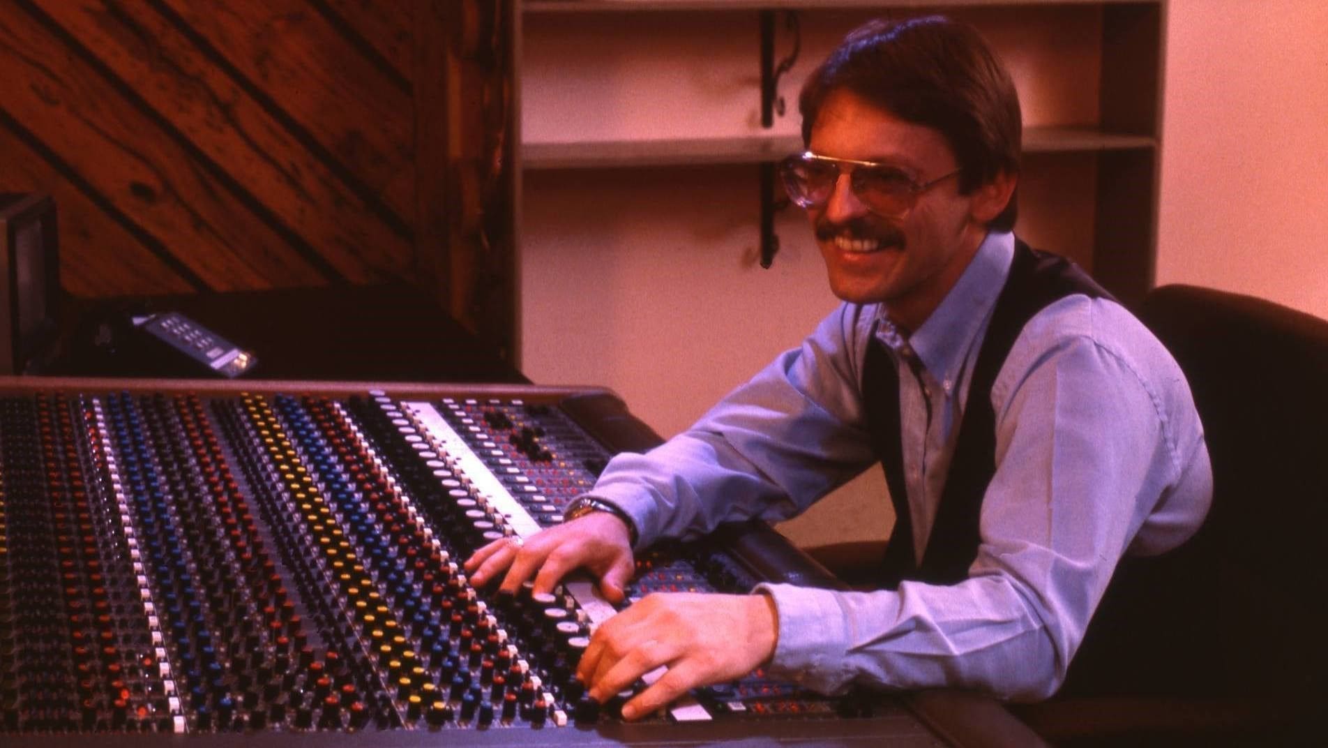Audio engineer working at a mixing console.