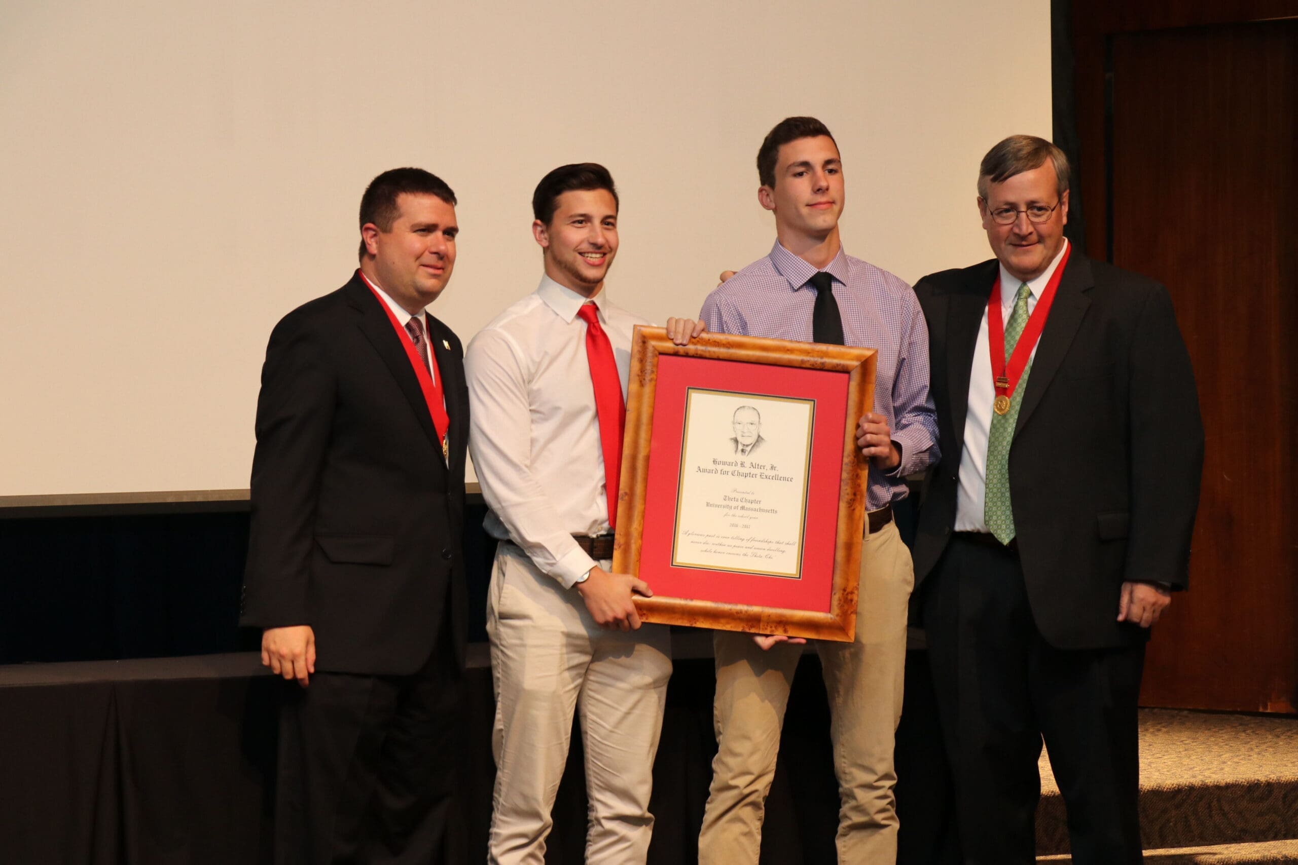 Students receiving award at ceremony event.