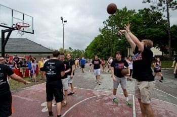 Group of people playing basketball outdoors.