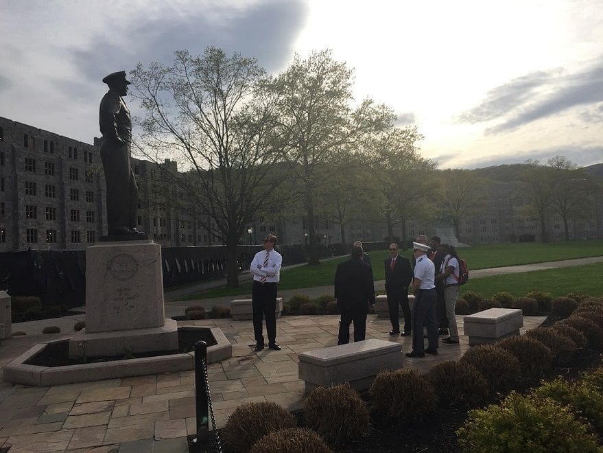 Group of people visiting a statue in a park.