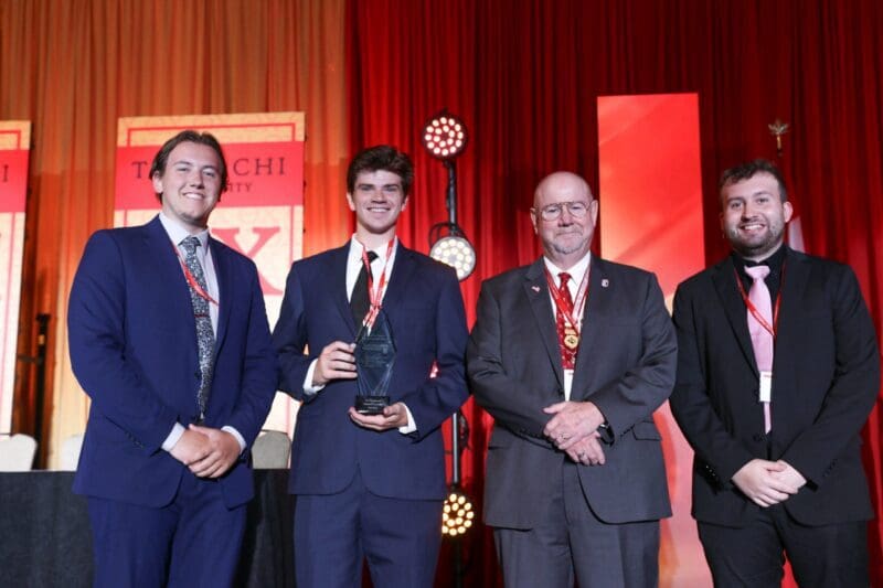 Students receiving award at university event.