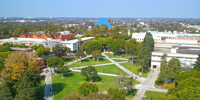 Aerial view of university campus with green spaces.
