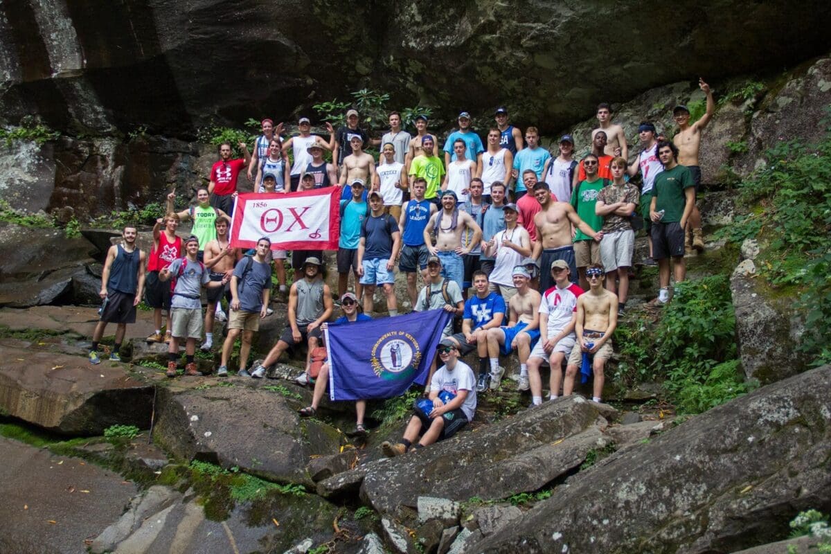 Group of young men posing with flags outdoors.
