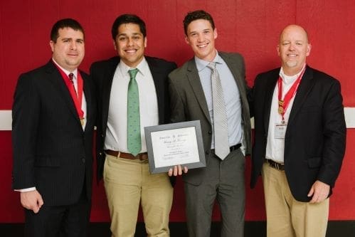 Four men celebrating an award presentation event.