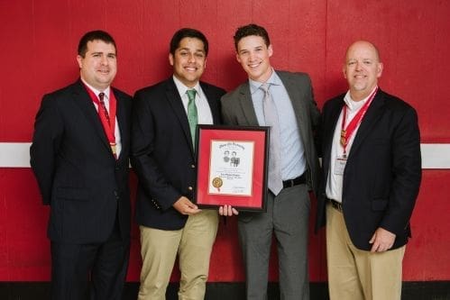 Group of men celebrating an award presentation.