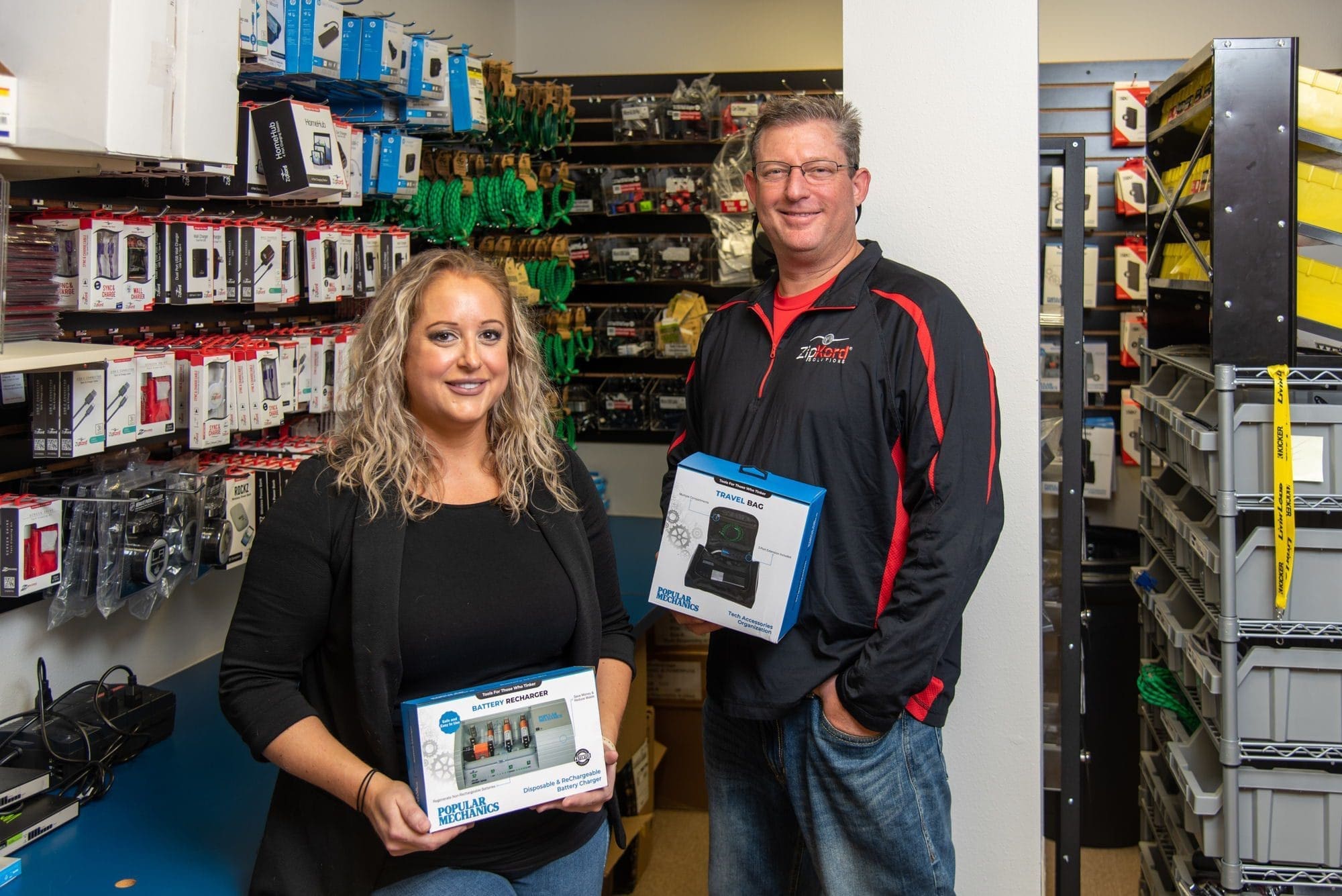 Tau - Florida - Jeff Rudd Two store employees showcasing electronic products.