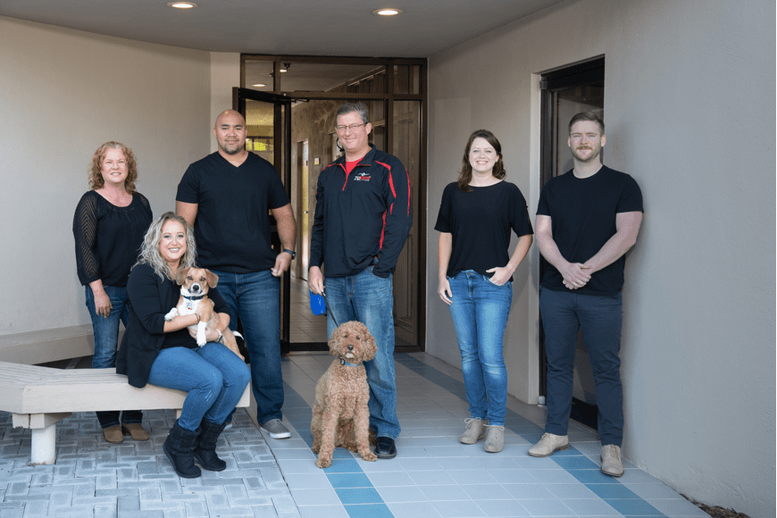 Tau - Florida - Jeff Rudd Group of people and dogs outside a building.