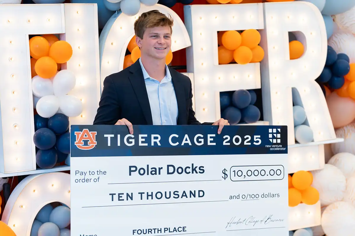 Vince Visser holding a large award check