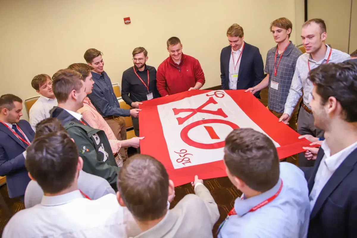 group of Theta Chi holding a flag
