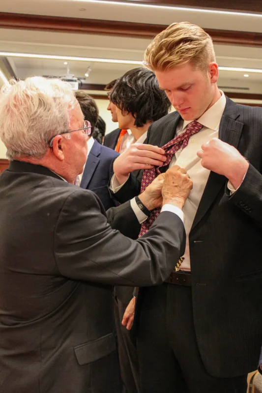a man helping a brother with his shirt
