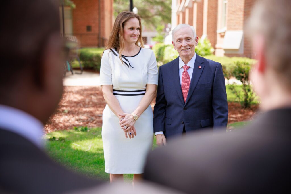 A man wearing a suit and a woman wearing a dress