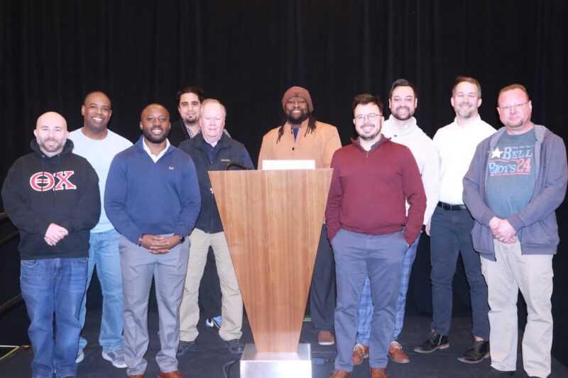 Men standing around a podium