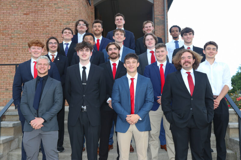 Brothers on stairs in suits at Initiative Academy