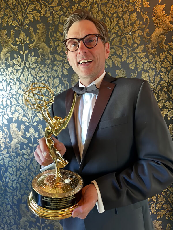 Casey Brumels holding his Emmy